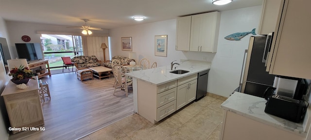 kitchen with white cabinetry, light stone countertops, black dishwasher, and kitchen peninsula