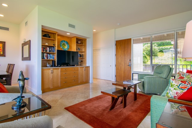 living room with built in features and light tile patterned floors