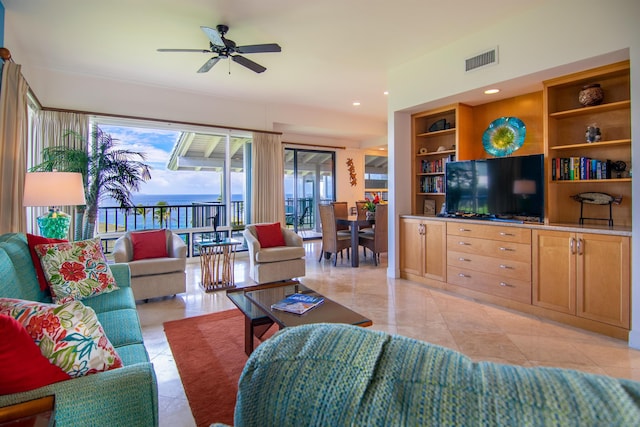 living room featuring built in features, light tile patterned flooring, and ceiling fan