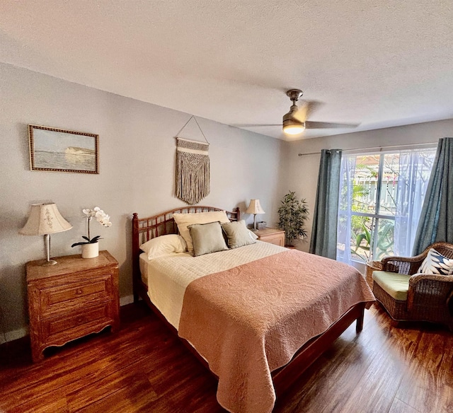bedroom featuring a textured ceiling, dark wood-style floors, and ceiling fan