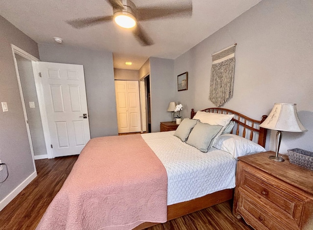 bedroom featuring a ceiling fan, baseboards, a closet, and dark wood finished floors