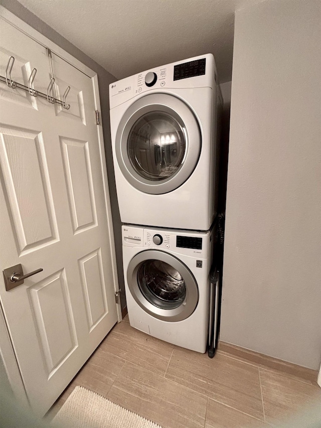 washroom featuring laundry area and stacked washing maching and dryer