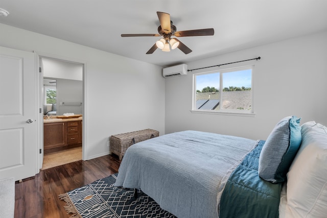 bedroom with a wall unit AC, ceiling fan, ensuite bath, and dark hardwood / wood-style flooring