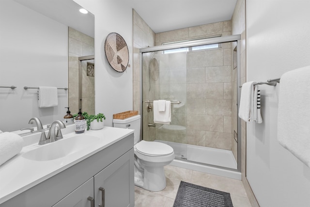 bathroom featuring toilet, an enclosed shower, vanity, and tile patterned floors