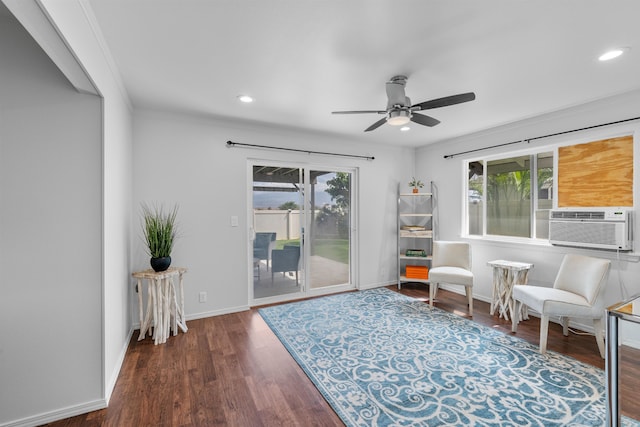 living area featuring dark wood-type flooring, ceiling fan, ornamental molding, and plenty of natural light