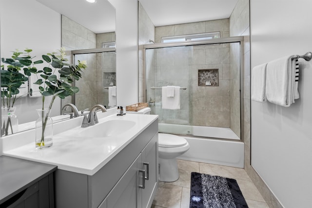 full bathroom with vanity, combined bath / shower with glass door, toilet, and tile patterned flooring