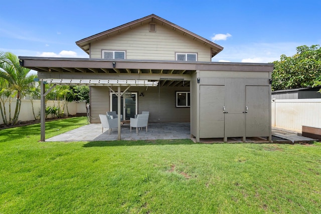 rear view of house featuring a storage shed, a patio area, and a lawn