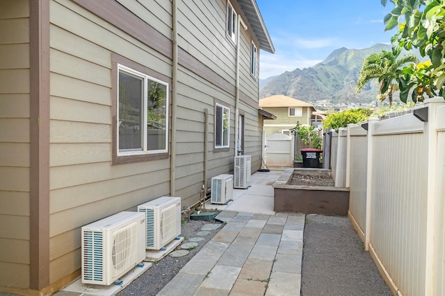 view of property exterior with a mountain view, a patio area, central AC unit, and ac unit