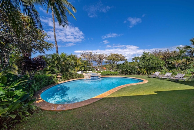 view of swimming pool featuring a lawn and an in ground hot tub