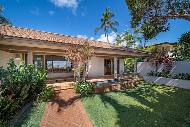 rear view of property featuring a lawn and a patio