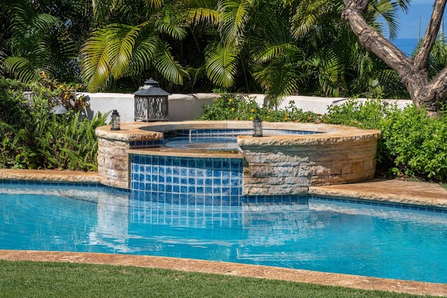 view of swimming pool with an outdoor hot tub