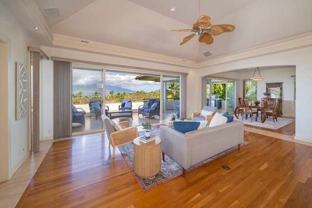 living room featuring light hardwood / wood-style floors, ceiling fan, and a tray ceiling