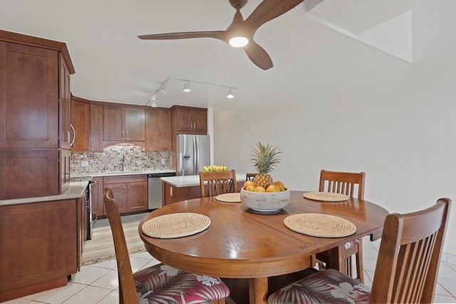 dining room featuring sink, light tile patterned floors, and ceiling fan