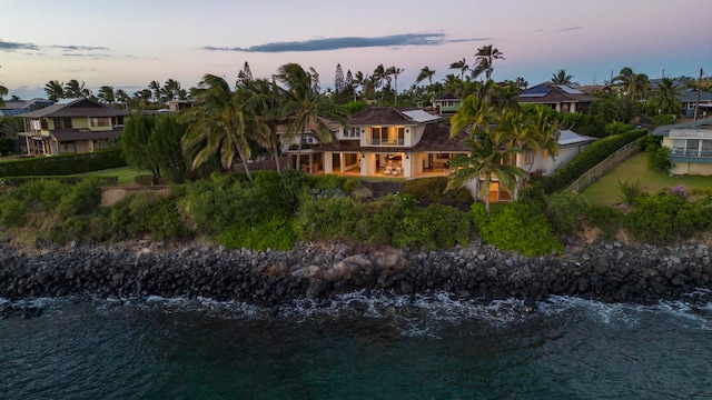 back house at dusk featuring a water view