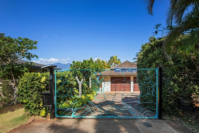 view of gate with fence and a mountain view