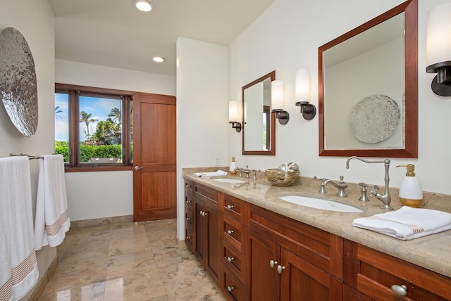 bathroom with double vanity, baseboards, a sink, and recessed lighting