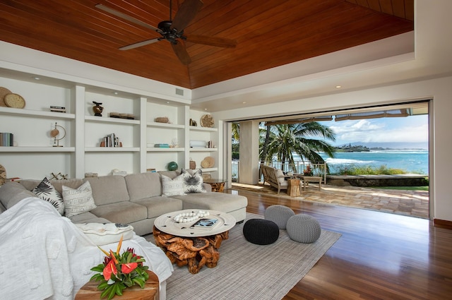 living room with wood-type flooring, ceiling fan, built in shelves, a water view, and wood ceiling