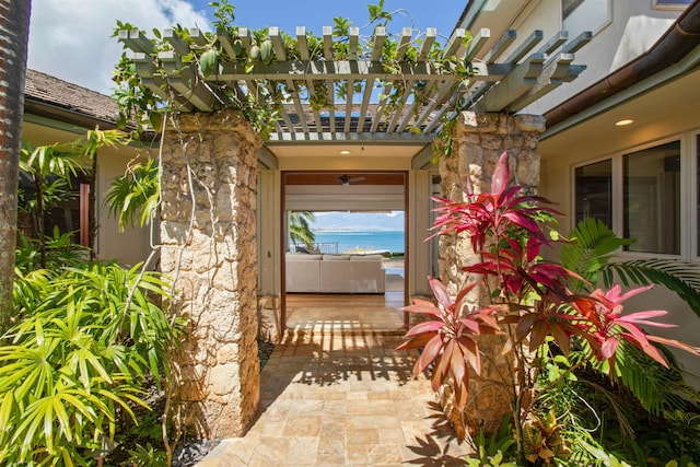 doorway to property with a water view and a patio area