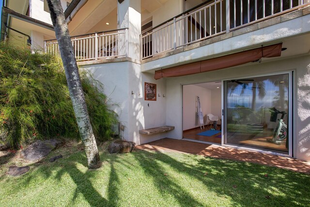 exterior space featuring a balcony and a lawn