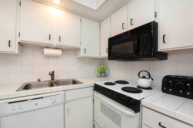 kitchen with sink, tile counters, white cabinetry, white appliances, and tasteful backsplash