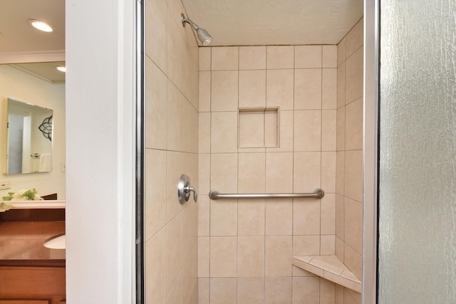 bathroom with tiled shower and vanity