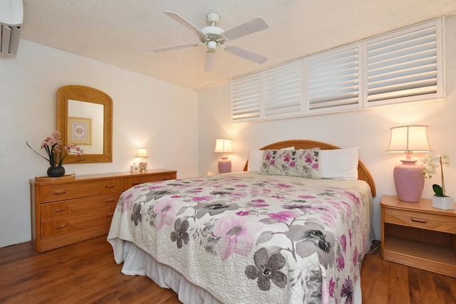 bedroom featuring ceiling fan, dark wood-type flooring, and a textured ceiling