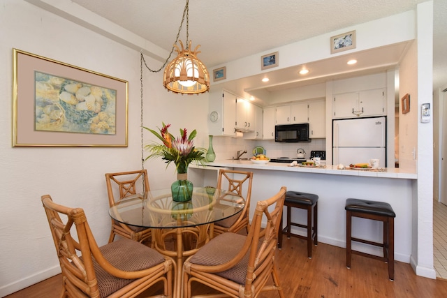 dining area featuring sink and hardwood / wood-style floors