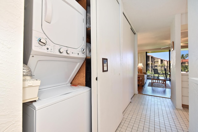 clothes washing area with light hardwood / wood-style floors and stacked washer and dryer