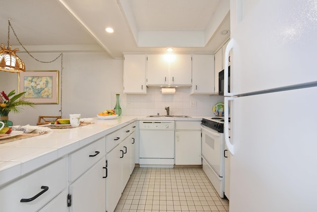 kitchen featuring tasteful backsplash, white cabinets, light tile floors, white appliances, and hanging light fixtures