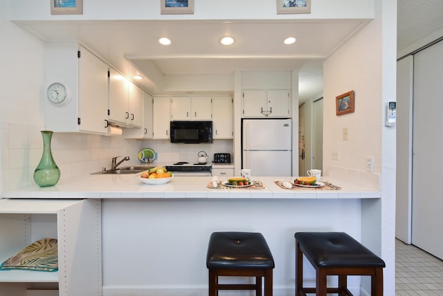 kitchen featuring tasteful backsplash, white appliances, light tile floors, sink, and white cabinetry