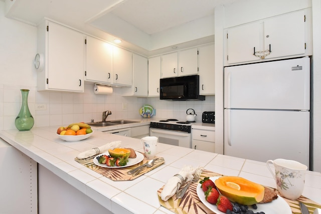 kitchen with sink, backsplash, tile countertops, and white appliances