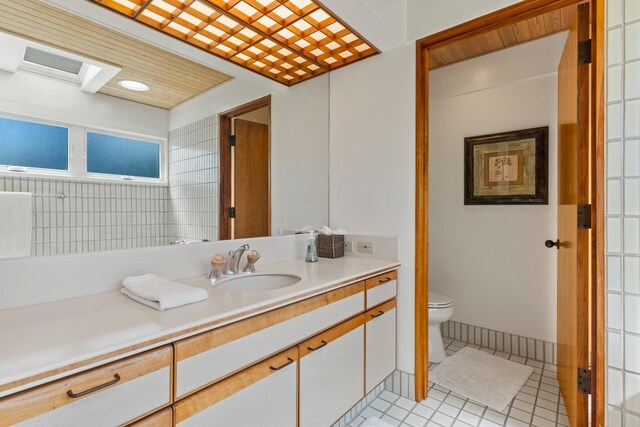 bathroom with vanity, toilet, and tile patterned flooring