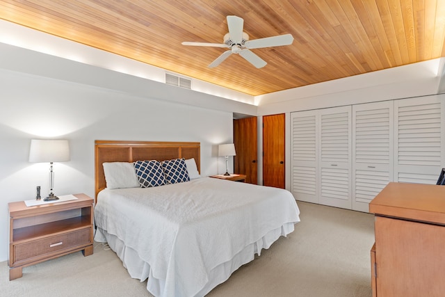 bedroom featuring wood ceiling, light colored carpet, and ceiling fan