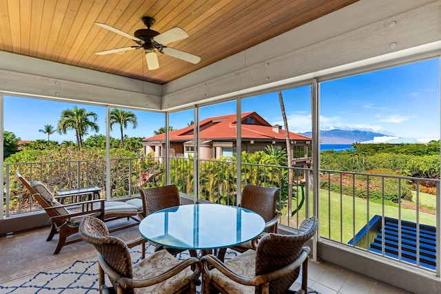 sunroom / solarium featuring wood ceiling, a mountain view, and ceiling fan