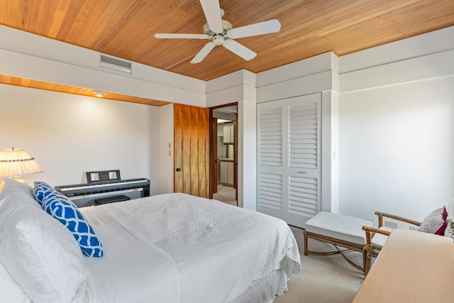 carpeted bedroom featuring a closet, wood ceiling, and ceiling fan