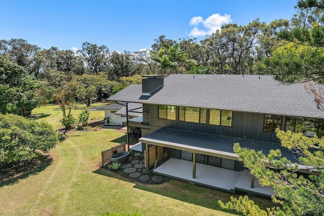 965 Hog Back Rd Unit 1, Haiku, HI 96708 - back of property with board and batten siding, a shingled roof, a lawn, and a chimney