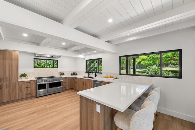 965 Hog Back Rd Unit 1, Haiku, HI 96708 - kitchen with stainless steel appliances, a peninsula, light countertops, brown cabinets, and modern cabinets