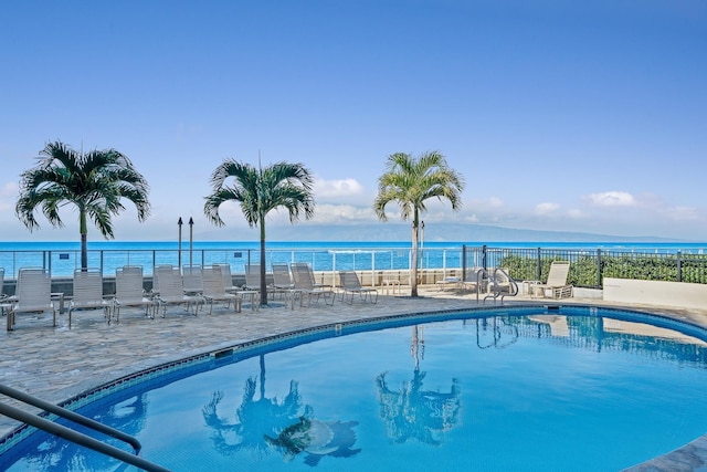 view of swimming pool featuring a patio area and a water view