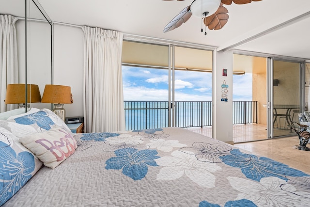 tiled bedroom with ceiling fan, access to exterior, and a wall of windows