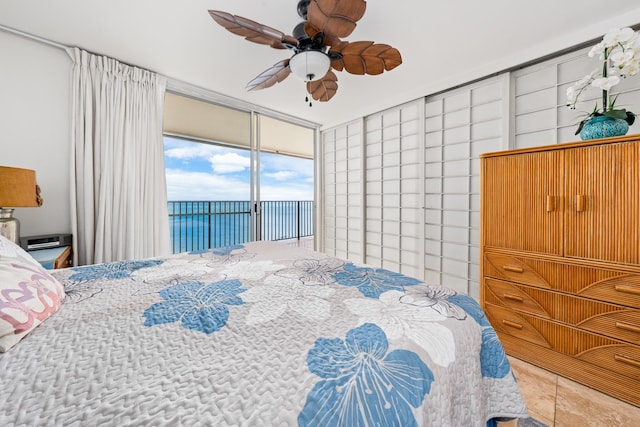 bedroom featuring ceiling fan, access to outside, a water view, and tile patterned flooring