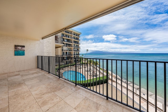 balcony featuring a water view and a view of the beach