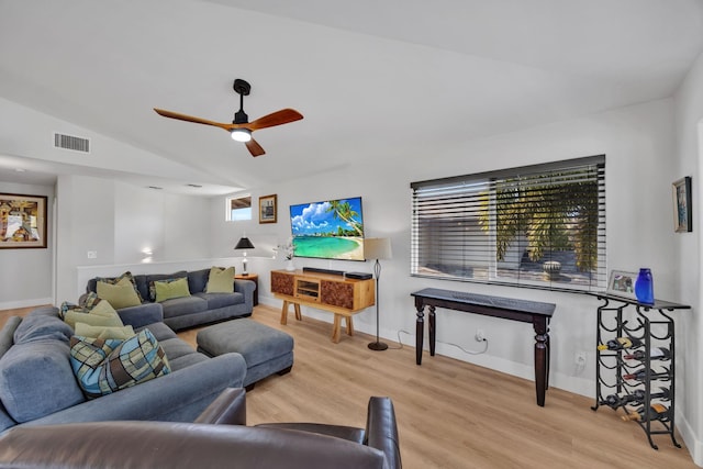 living area with visible vents, ceiling fan, vaulted ceiling, wood finished floors, and baseboards