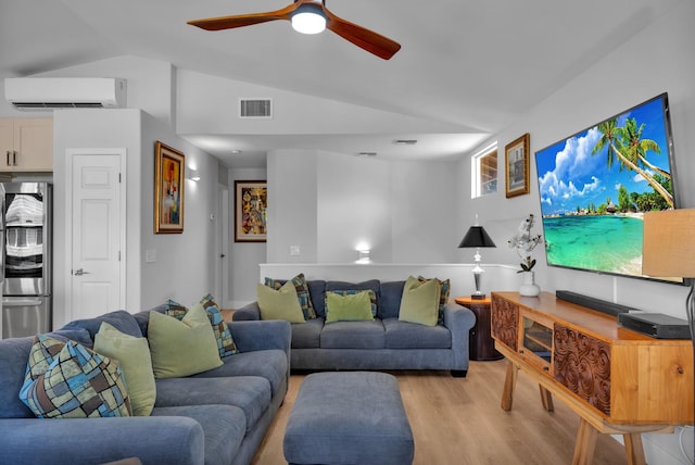 living area with ceiling fan, visible vents, vaulted ceiling, a wall mounted AC, and light wood finished floors