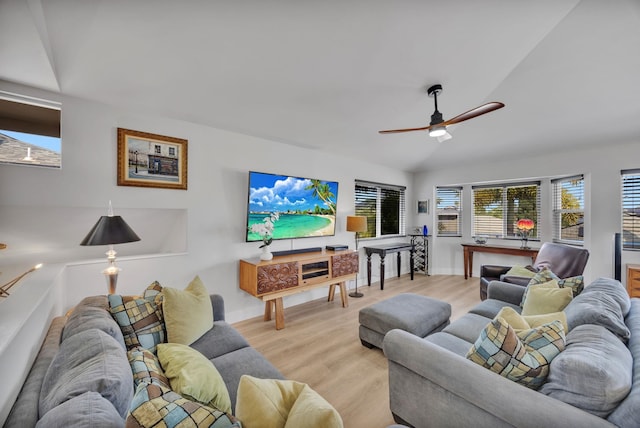 living area with a ceiling fan, lofted ceiling, light wood-style flooring, and baseboards