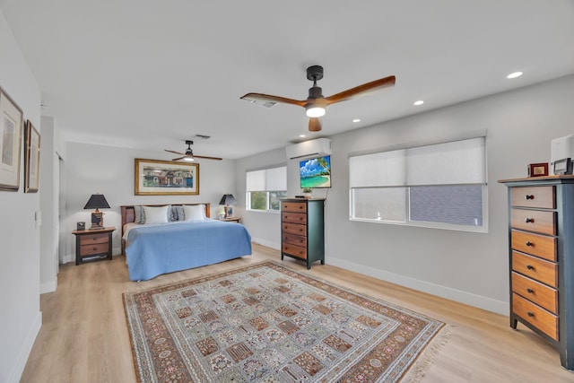 bedroom featuring light wood-type flooring, recessed lighting, a wall unit AC, and baseboards