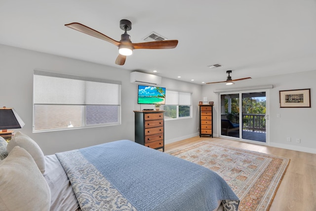 bedroom with visible vents, wood finished floors, access to outside, a wall mounted air conditioner, and baseboards