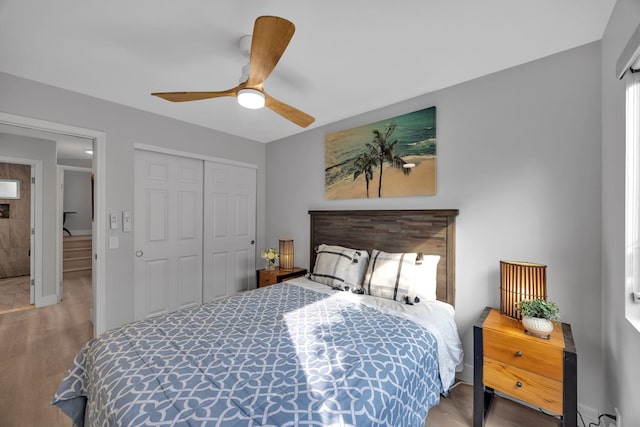 bedroom featuring a ceiling fan, a closet, and wood finished floors