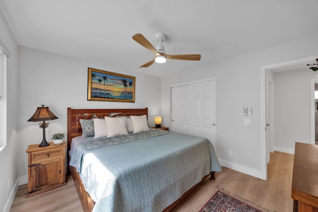 bedroom with a closet, baseboards, ceiling fan, and light wood finished floors