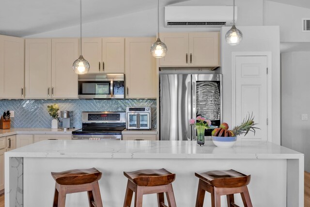 kitchen featuring lofted ceiling, visible vents, decorative backsplash, appliances with stainless steel finishes, and an AC wall unit