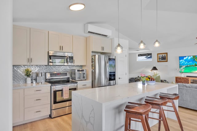 kitchen with tasteful backsplash, appliances with stainless steel finishes, open floor plan, vaulted ceiling, and a wall mounted AC